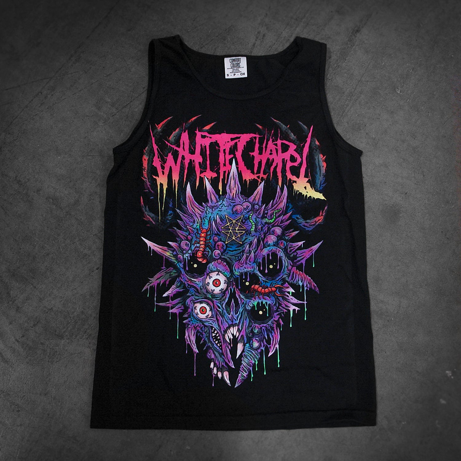 Whitechapel black tank top made from soft Comfort Colors fabric, featuring a horror-inspired graphic with monstrous faces and sharp teeth beneath the band’s jagged red, yellow, and purple logo—ideal for bold style fans.