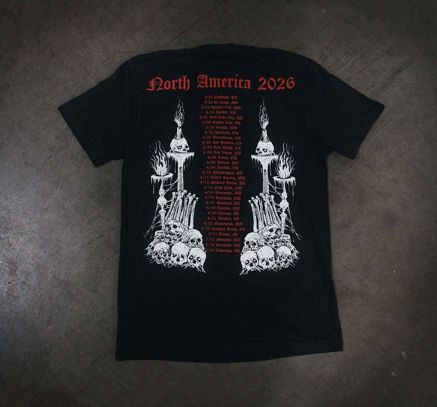 The Whitechapel Black Comfort Colors T-Shirt is garment-dyed, made from soft ring-spun cotton, and showcases “North America 2026” in bold red with tour dates, cities, and striking skulls, bones, candles, and flames illustrated on the back.