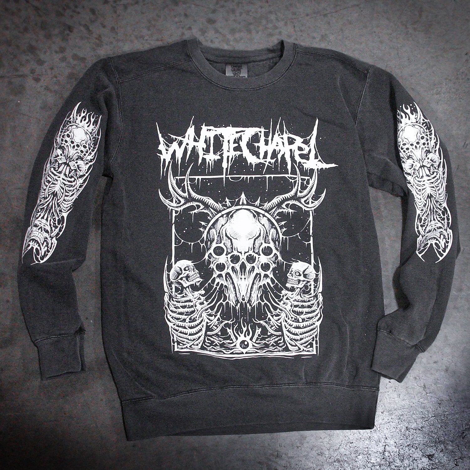 The Whitechapel crewneck sweatshirt features black garment-dyed fabric with bold white death metal art—a horned skull, skeletal figures, 