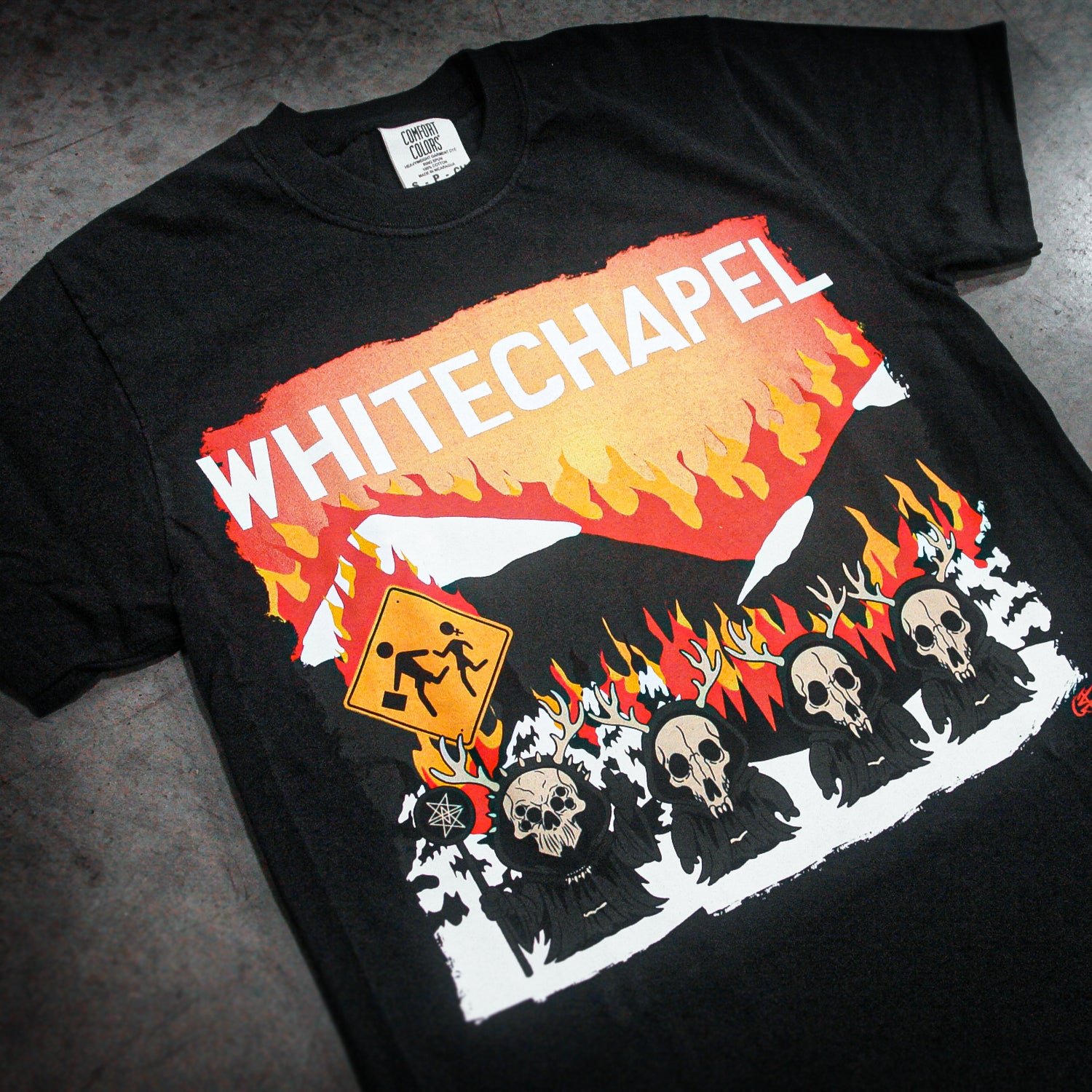 Black t-shirt with 'Whitechapel' graphic design featuring skulls and flames on a gray surface.