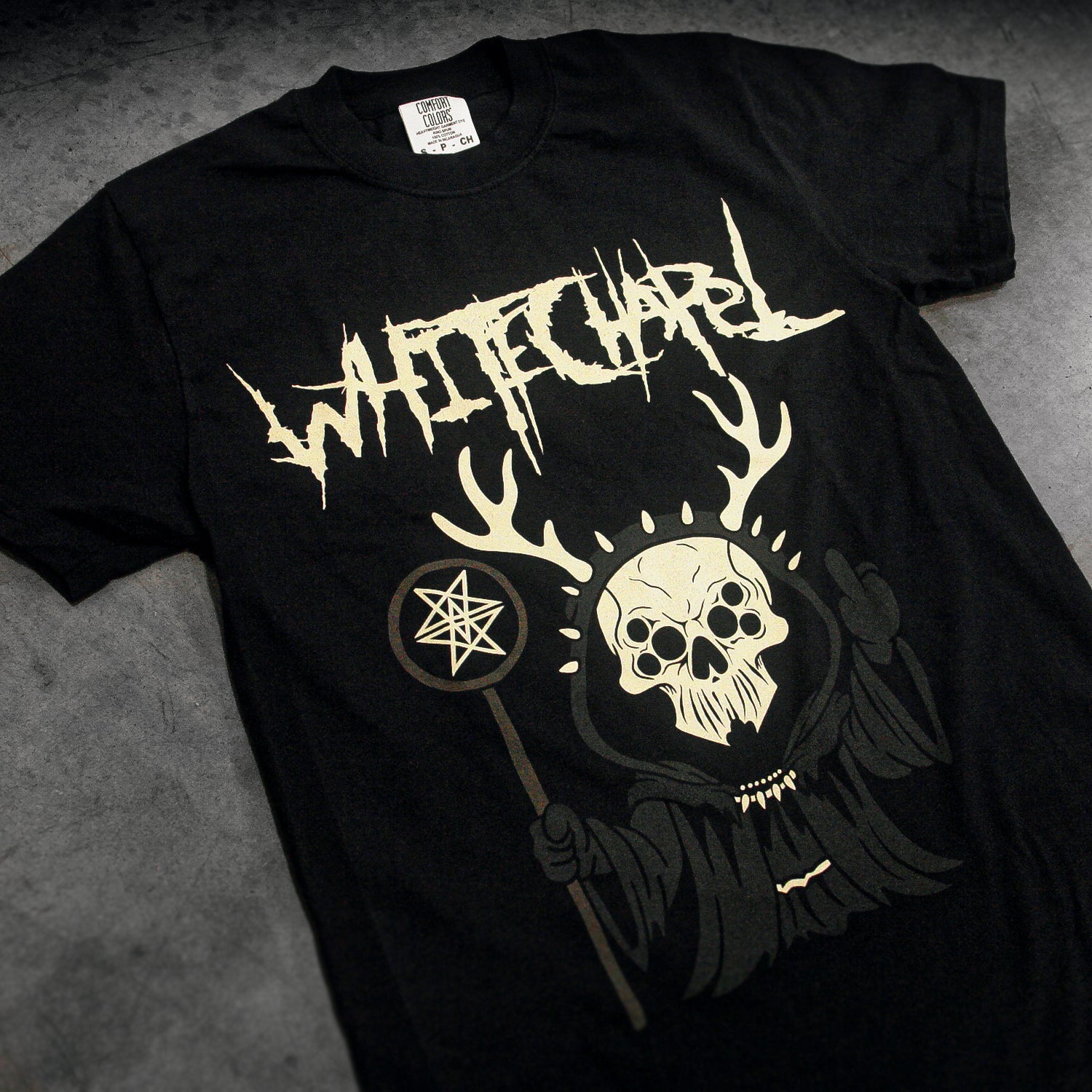 Black t-shirt with white graphic design featuring a skull and antlers on a gray surface